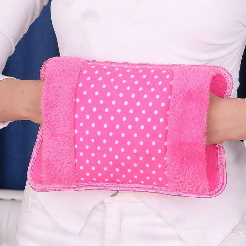 Pink heating pad with white polka dots on a person's arm